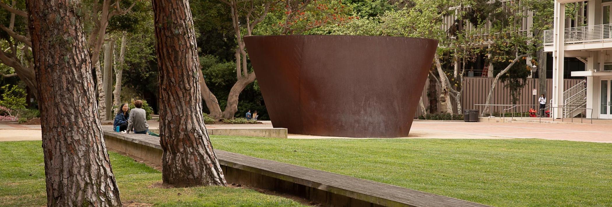 North Campus with lawn, trees, and a sculpture by Richard Serra